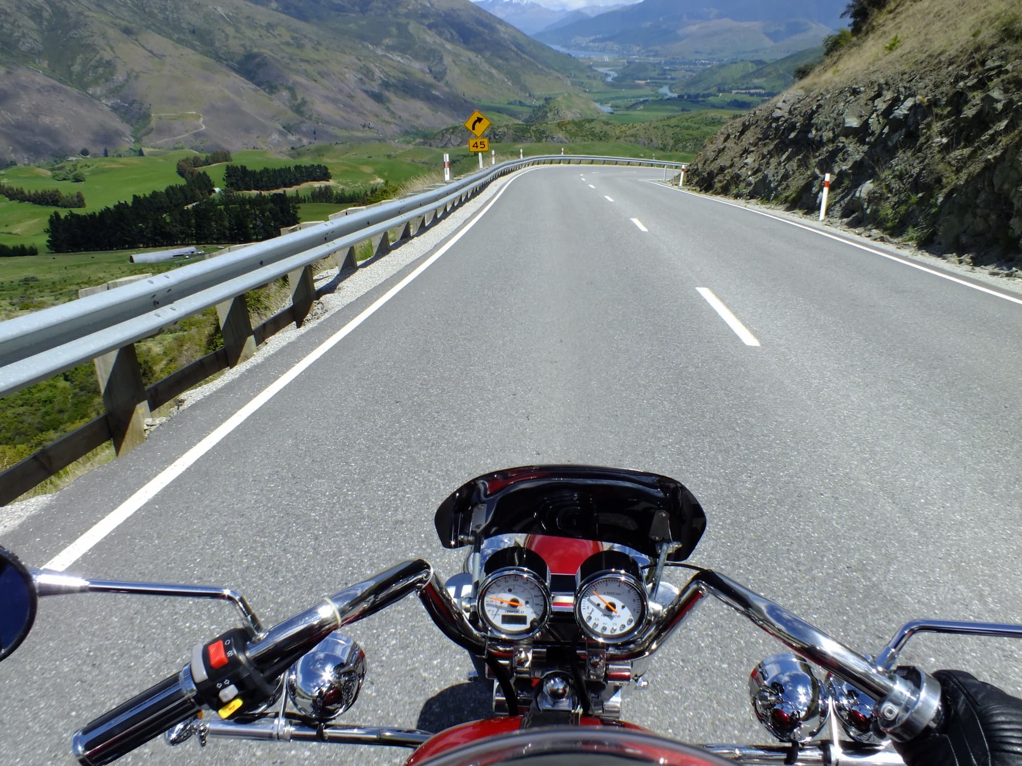 Rider's view over trike handlebars on an open mountain highway