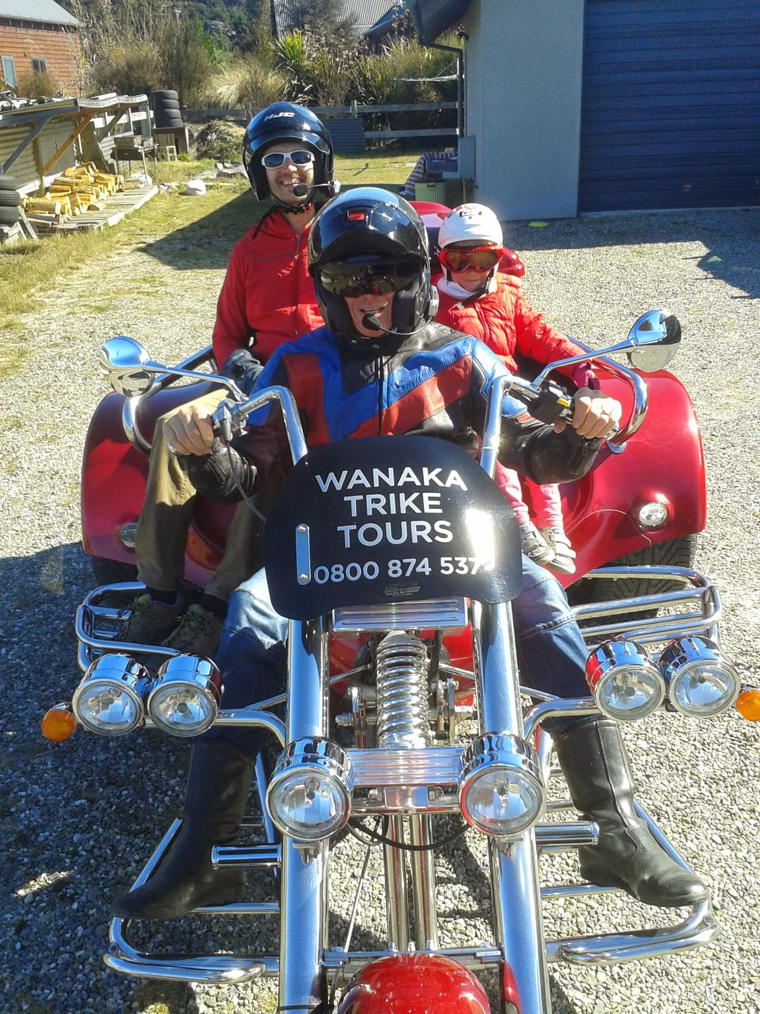 Rider and passengers on a red Rewaco trike, front view