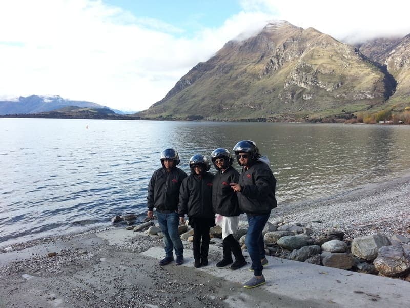 Guests on the lakeshore with mountains behind